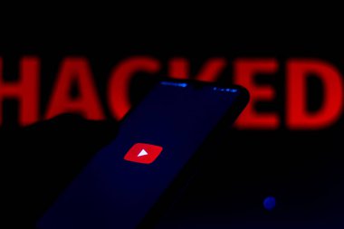 15 Haziran 2020, Brezilya. Bu resimde YouTube logosu bir akıllı telefon ve kırmızı uyarı kelimesi üzerinde bulanık arkaplanda HACKED gösterilir.