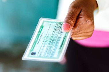 4 Temmuz 2020, Brezilya. Seçmen Lisansı (Titulo Eleitoral) kadının elinde. Brezilya seçimlerinde oy kullanabileceğini kanıtlayan bir belge.