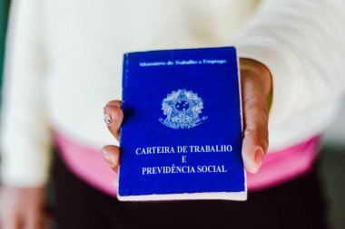 4 Temmuz 2020, Brezilya. Kadın, Brezilya belgelerini ve sosyal güvenceyi elinde tutmaktadır (Carteira de Trabalho e Previdencia Social)