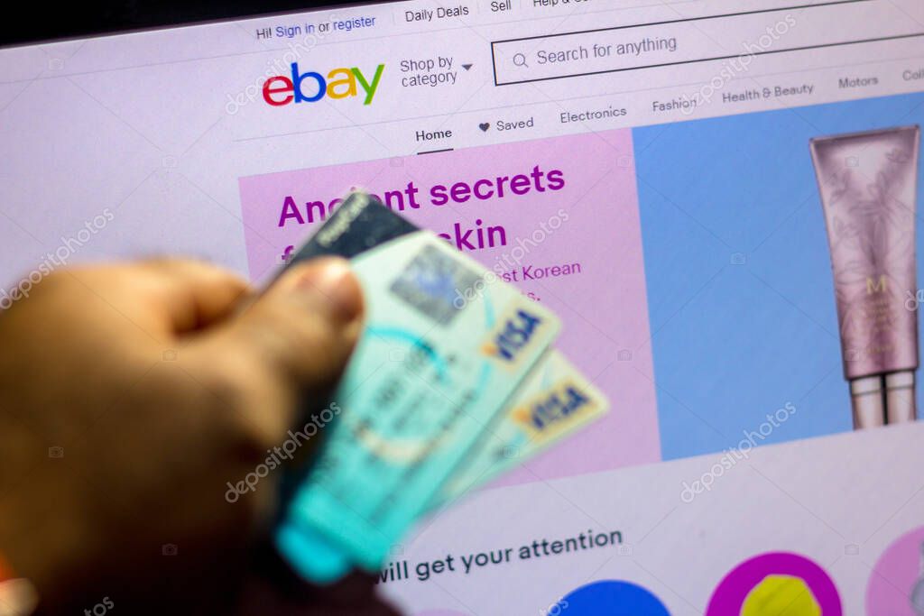 July 5, 20020, Brazil. The eBay website is shown on a laptop in the background and a person holds a bank card