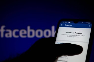 10 Temmuz 2020, Brezilya. Bu resimde akıllı telefondan gösterilen Telegram logosu var. Arka plandaki bilgisayar ekranında Facebook logosu