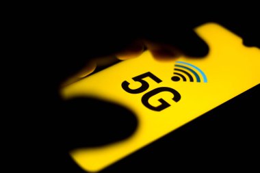 Bu resimde kişi mobil internette sörf yapıyor. 5G yazıtları akıllı telefon ekranında görüntülenir