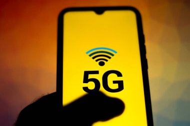 Bu resimde kişi mobil internette sörf yapıyor. 5G yazıtları akıllı telefon ekranında görüntülenir