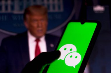 28 Eylül 2020, Brezilya. Bu resimde akıllı bir telefondan WeChat logosu gösteriliyor. Arka planda Başkan Donald Trump var. Uygulama ABD 'de yasaklandı