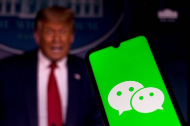 28 Eylül 2020, Brezilya. Bu resimde akıllı bir telefondan WeChat logosu gösteriliyor. Arka planda Başkan Donald Trump var. Uygulama ABD 'de yasaklandı