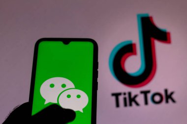 28 Eylül 2020, Brezilya. Bu resimde arka planda TikTok logosu olan akıllı bir telefondan WeChat logosu gösteriliyor.