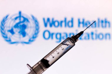 2 Ekim 2020, Brezilya. Bu resimde tıbbi şırınga Dünya Sağlık Örgütü (WHO) logosu arka planda bir ekranda gösteriliyor.