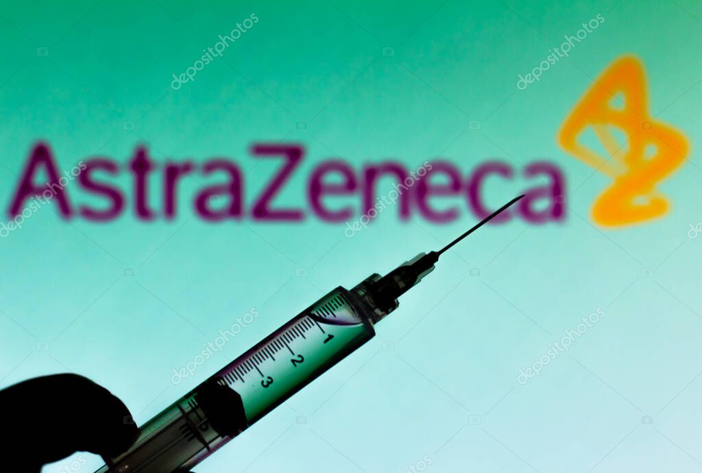 October 2, 2020, Brazil. In this photo illustration the medical syringe is seen with AstraZeneca company logo displayed on a screen in the background
