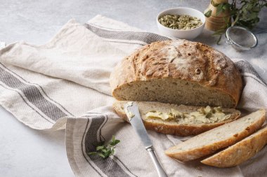 Ev yapımı tam tahıl ekmek ve tereyağı ve kabak çekirdeği kahvaltıda dilimle.