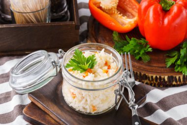 Dolmalık biber ve maydanoz öğle yemeği için bir kavanoza buğulama veya haşlanmış pirinç. Sağlıklı organik gıda kavramı.