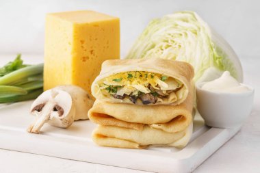 Yığın vejetaryen krep veya blintzes lahana, mantar ve peynir Dolum ve yemek pişirmek için malzemeler.