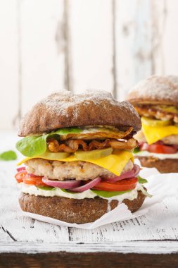 Öğle yemeği için pastırma, marul, domates, mayonez soslu tavuk çizburger.