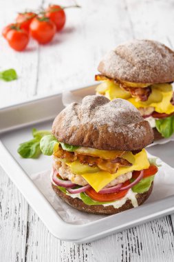 Öğle yemeği için pastırma, marul, domates, mayonez soslu tavuk çizburger.