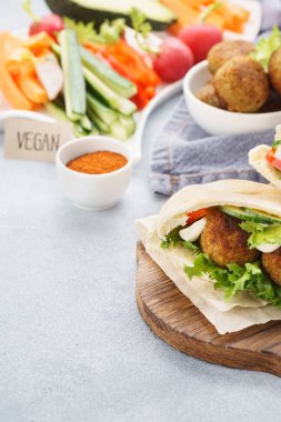 Pita ekmekler falafel, taze sebze çubukları ve sos ile.