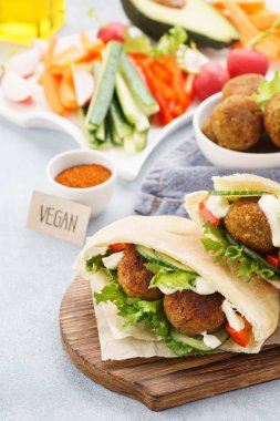 Pita ekmekler falafel, taze sebze çubukları ve sos ile.