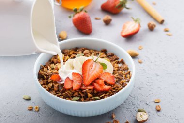 Granola dökülen süt, muz ve çilek ile.