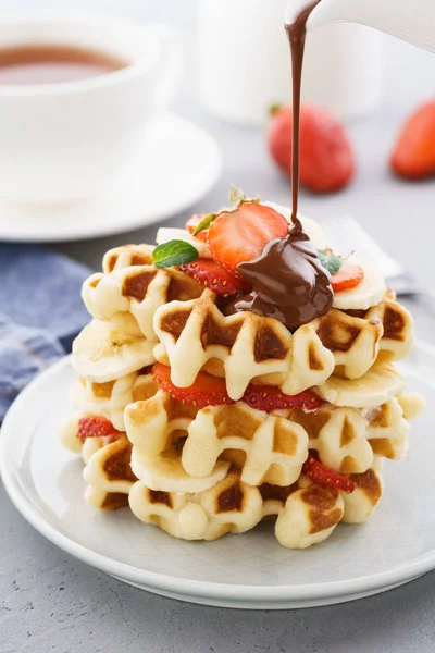 Stack of waffles with banana, strawberry and flowing chocolate. — Stock Photo, Image