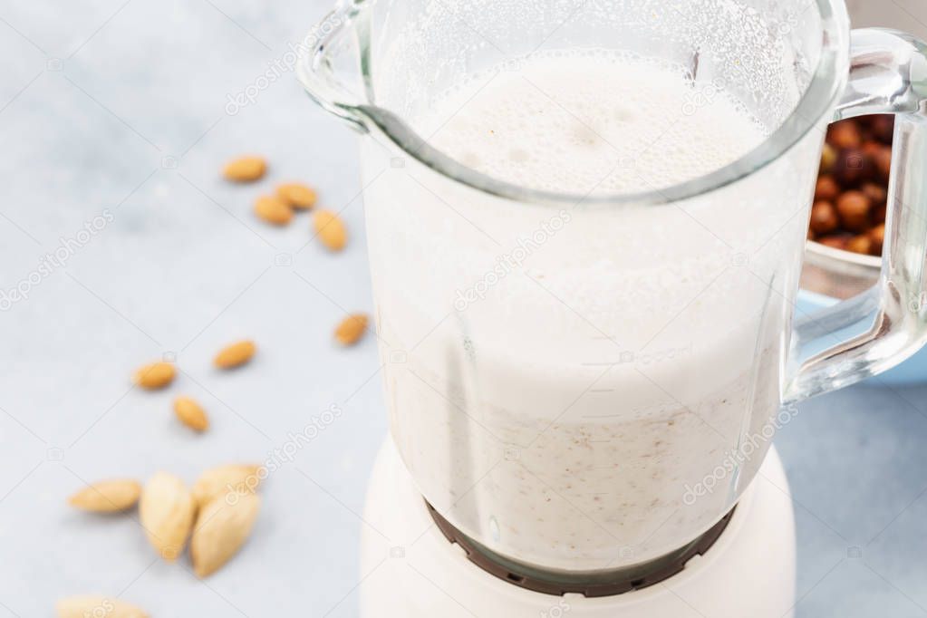 Homemade nut milk in blender and ingredients.