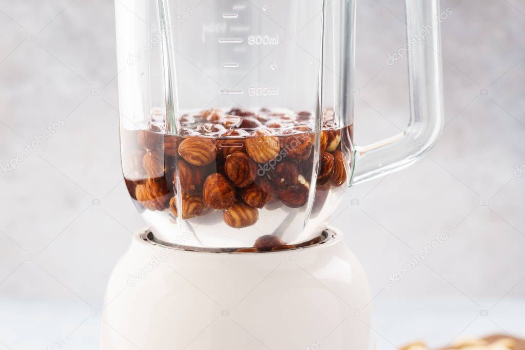 Soaked hazelnuts in blender. Making vegan nut milk.