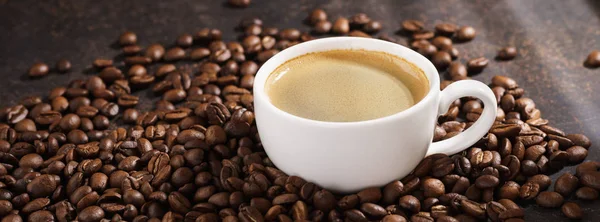 Xícara de café em grãos de café torrados. Raios solares no fundo . — Fotografia de Stock