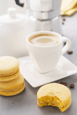 Sarı Fransız macarons meyve doldurma ve bir fincan espresso ile.