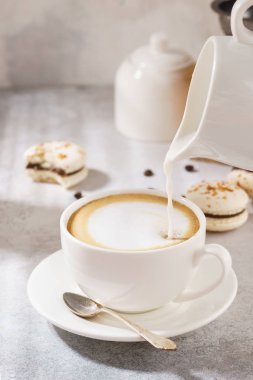 Kahve ve süt bir kaba dökme. Tatlı olarak Fransız macarons.