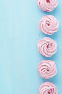 Pastel mavi zemin üzerine çilek marshmallow. Boşaltmak.