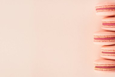 Aynı renkli arka planda pembe Makaron satırı.