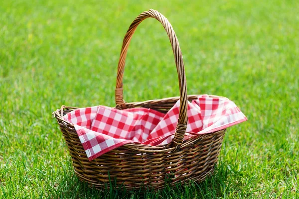 Yeşil güneşli çim üzerinde boş piknik sepeti. — Stok fotoğraf