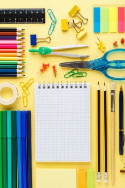 Sarı arka plan üzerinde okul kırtasiye ile düz yatıyordu kompozisyon