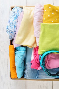 Nakliye veya bağış için bir kutu içinde çeşitli renkli giysiler.