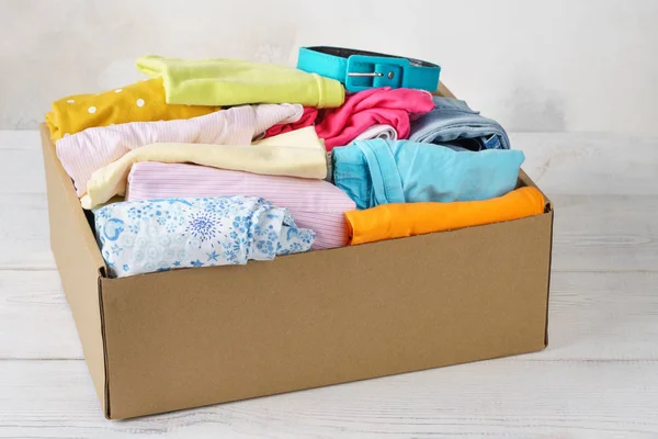 Διάφορα πολύχρωμα ρούχα σε ένα κουτί για ναυτιλία ή δωρεά. — Φωτογραφία Αρχείου