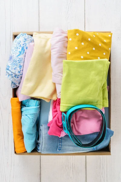 Διάφορα πολύχρωμα ρούχα σε ένα κουτί για ναυτιλία ή δωρεά. — Φωτογραφία Αρχείου
