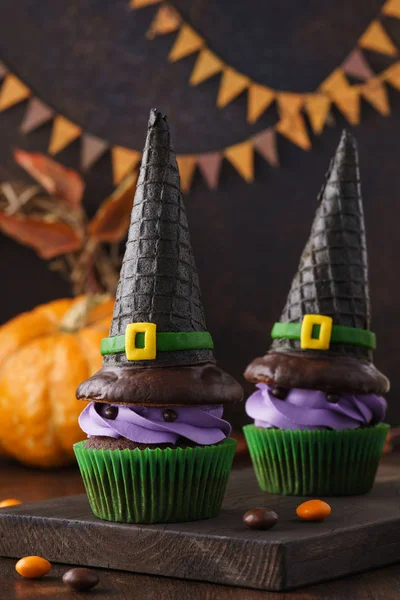 Halloween cupcake monsters with wafer witch hats and candies.