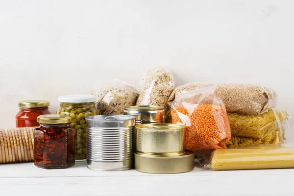 Divers aliments en conserve et céréales crues sur une table . — Photo