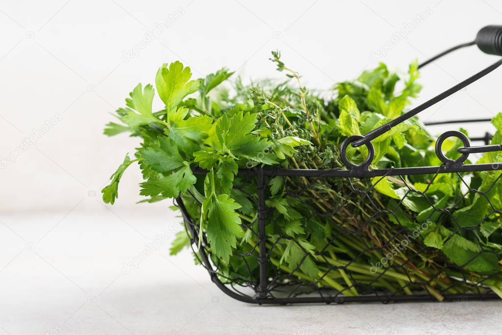 Basket with a variety of fresh green culinary herbs.