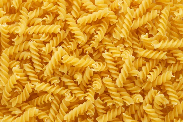 Suche niegotowane Fusilli makaron jako tło. — Zdjęcie stockowe