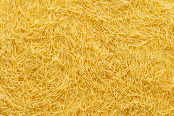 Bir arka plan olarak kuru pişmemiş erişte makarna.