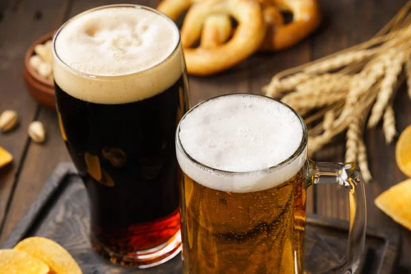 Two glasses of beer - light and dark with various snacks. — Stock Photo, Image