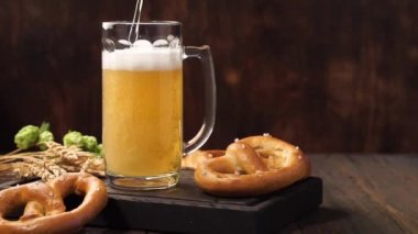 Lager birası bir kupaya akıyor. Ahşap bir masada hafif bira.