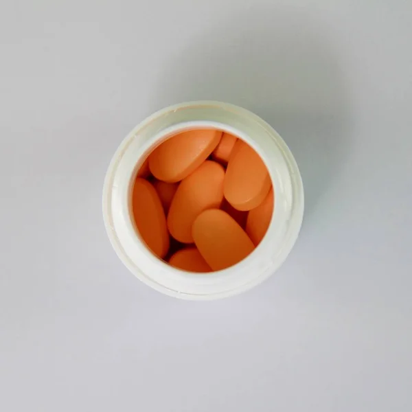 コンテナーにオレンジ色の錠剤 — ストック写真