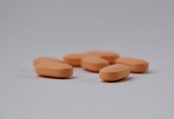 Апельсиновые таблетки на белом фоне
