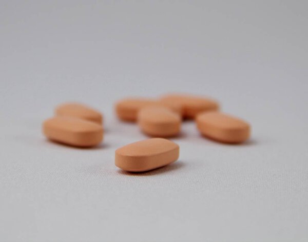 Апельсиновые таблетки на белом фоне
