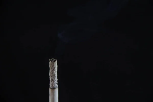 黒い背景にタバコを吸う — ストック写真