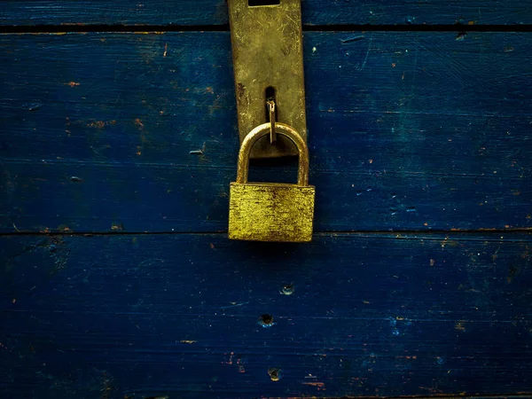 gold padlock locking the blue wood box