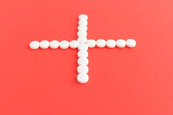 Tabletten geneeskunde voor de gezondheid van de volkeren om te genezen van ziekten, de Spilled witte pillen op het witte oppervlak (bovenaanzicht). — Stockfoto
