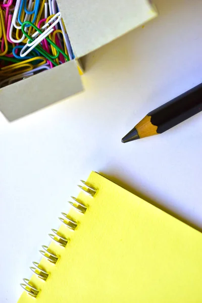 Black large pencil and Notepad and paper clips