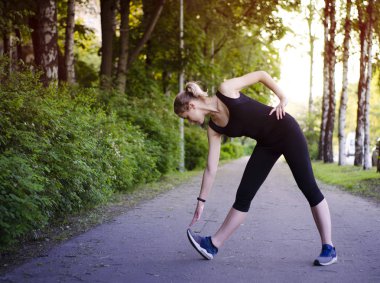 Parkta egzersiz yapan kız.