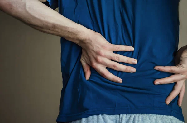 Un hombre sosteniendo su espalda. Dolor de espalda . —  Fotos de Stock