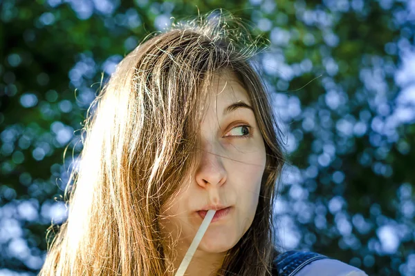 Chica bebiendo un trago de un tubo . — Foto de Stock